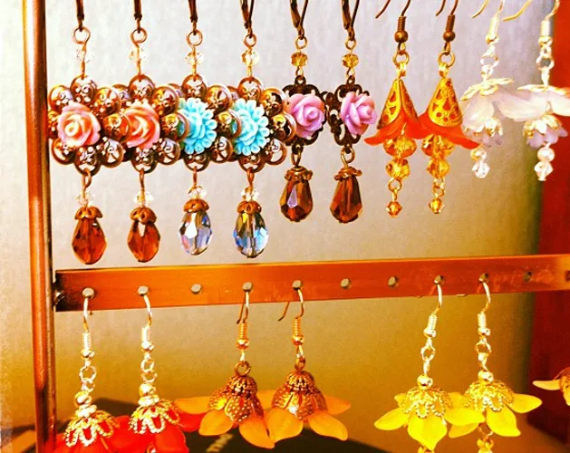 Display of colorful floral drop earrings in warm tones